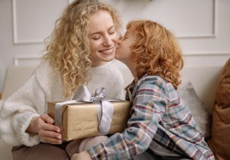 Boy Kissing His Mother Holding a Gift